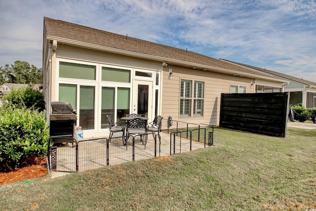 back of house featuring a lawn and a patio