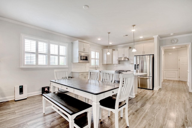 dining room featuring ornamental molding and light hardwood / wood-style floors