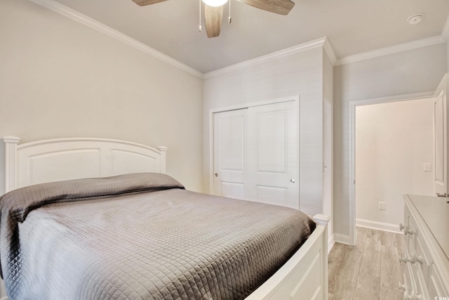 bedroom with ceiling fan, ornamental molding, a closet, and light hardwood / wood-style flooring