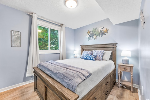 bedroom featuring a textured ceiling and light wood-type flooring