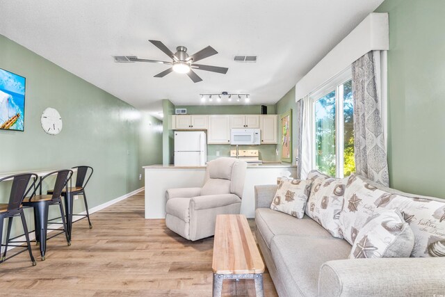 living room with light hardwood / wood-style floors and ceiling fan