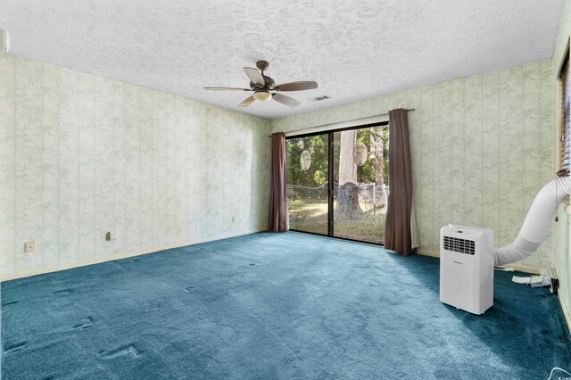 spare room with carpet floors, ceiling fan, a textured ceiling, and visible vents