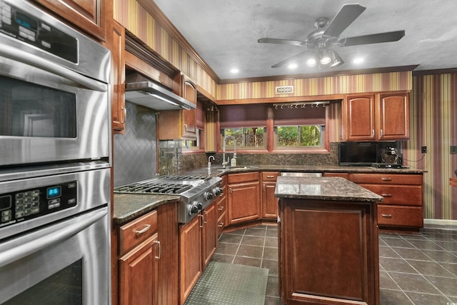 kitchen featuring ceiling fan, dark tile patterned flooring, tasteful backsplash, a sink, and stainless steel appliances