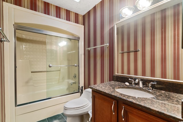 bathroom with a textured ceiling, tile patterned flooring, vanity, bath / shower combo with glass door, and toilet