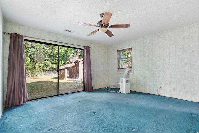 unfurnished room with carpet floors, a ceiling fan, a textured ceiling, and visible vents