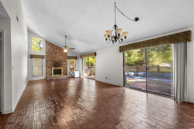 unfurnished living room featuring wood finished floors, a fireplace, a textured ceiling, ceiling fan with notable chandelier, and vaulted ceiling