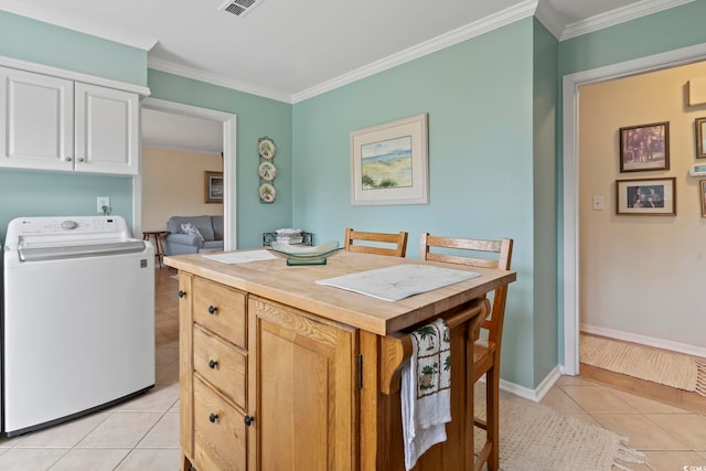 interior space with crown molding, washer / clothes dryer, and light tile patterned floors