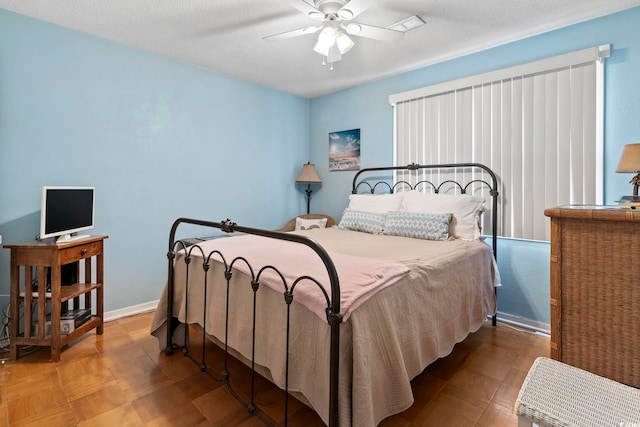 bedroom with a textured ceiling and ceiling fan