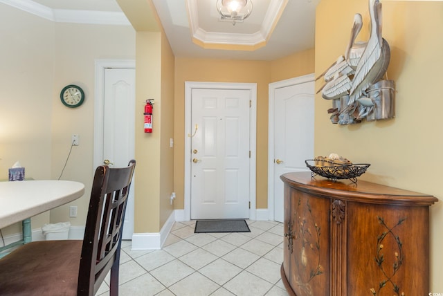 tiled entrance foyer with a tray ceiling and crown molding