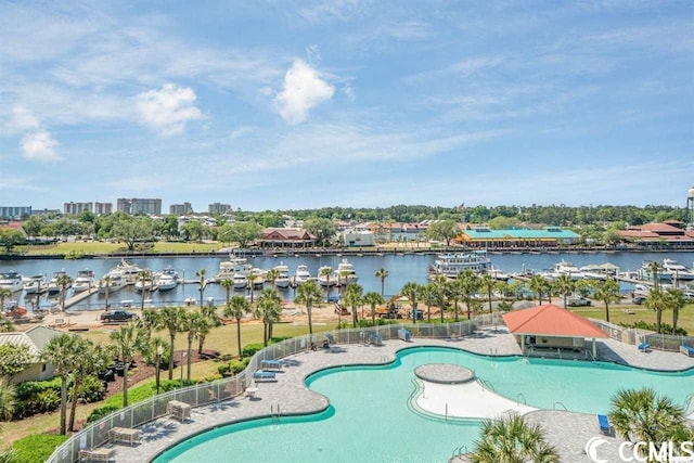 view of swimming pool featuring a water view and a patio area