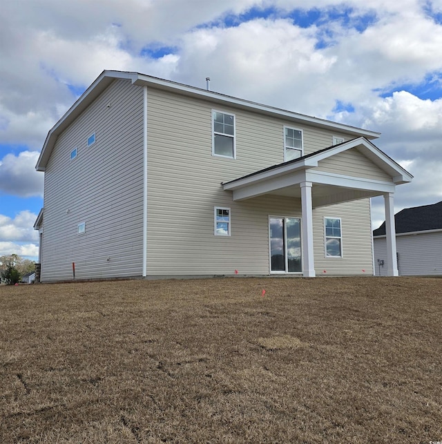 back of house with a lawn