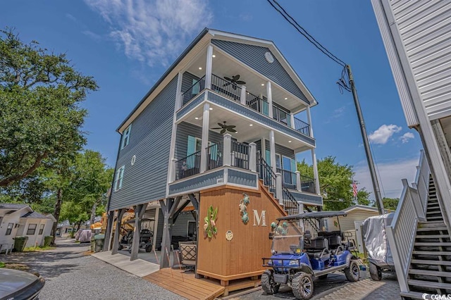 view of front of home featuring ceiling fan and a balcony