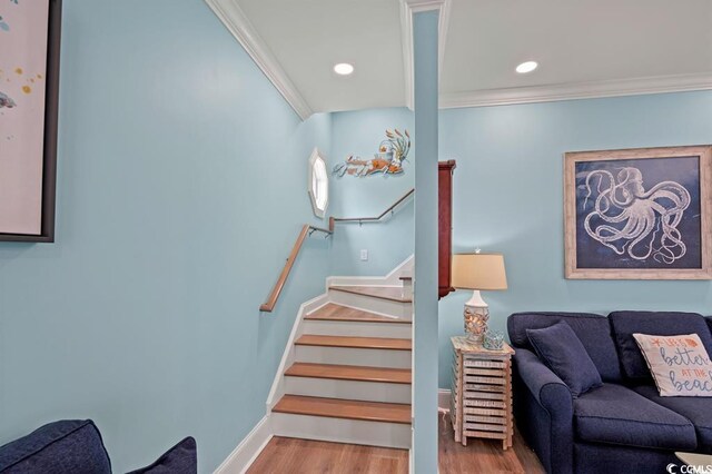 stairs featuring crown molding and wood-type flooring