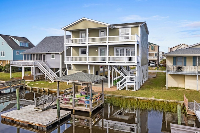 dock area with a deck with water view and a lawn