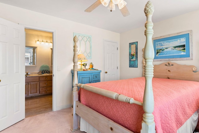 bedroom featuring light carpet, ensuite bath, and ceiling fan