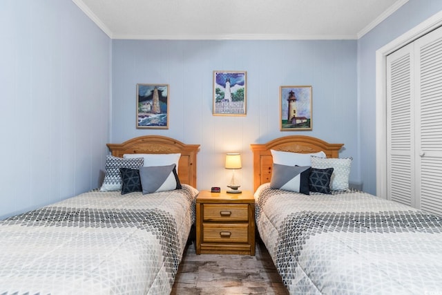 bedroom with a closet, ornamental molding, hardwood / wood-style flooring, and wood walls