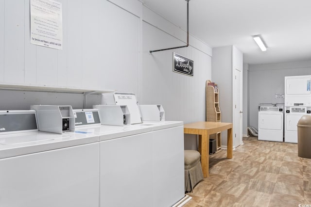 laundry room featuring wood walls, stacked washer and dryer, and washer and clothes dryer