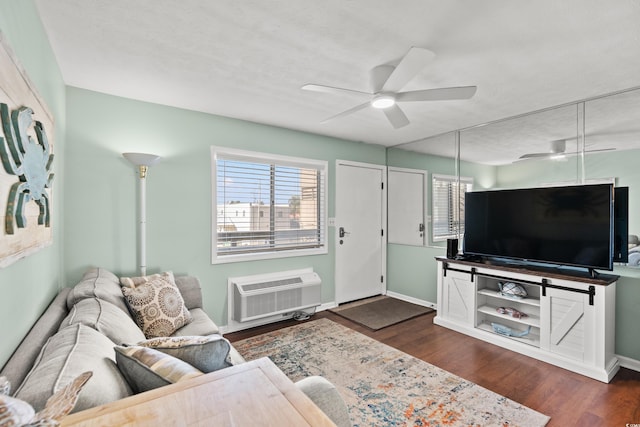 living room featuring dark wood-type flooring, ceiling fan, a textured ceiling, and a wall unit AC