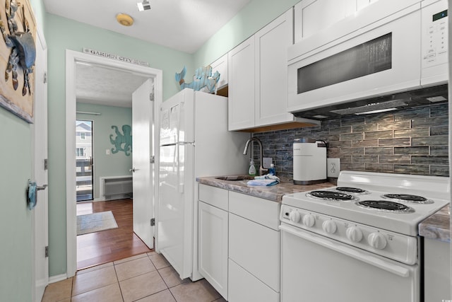 kitchen featuring decorative backsplash, white cabinetry, and white appliances