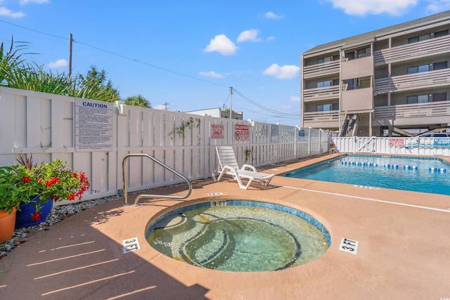 view of swimming pool featuring a patio area and a community hot tub