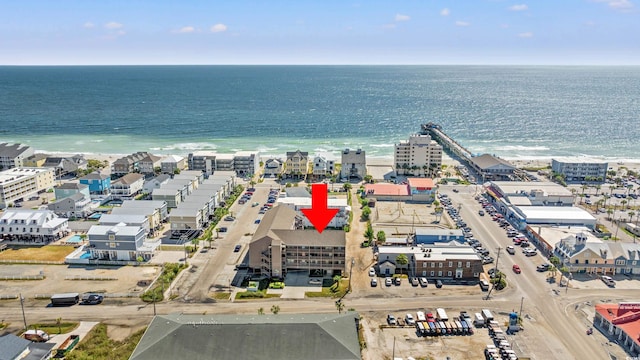 birds eye view of property with a water view and a beach view