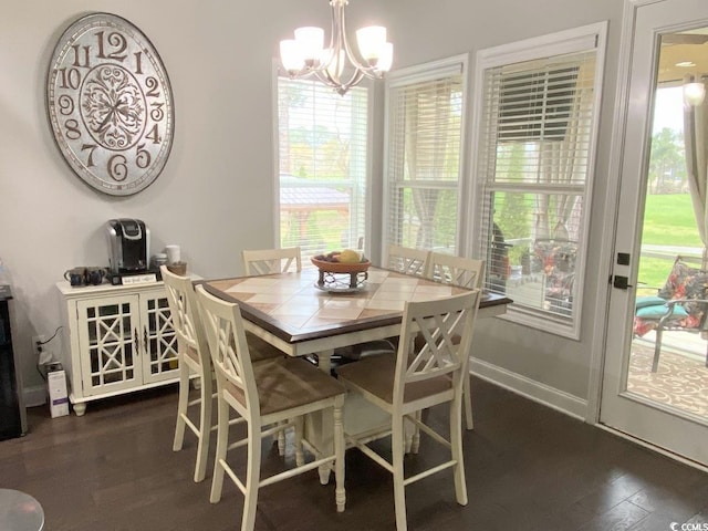 dining space with dark hardwood / wood-style flooring and a notable chandelier