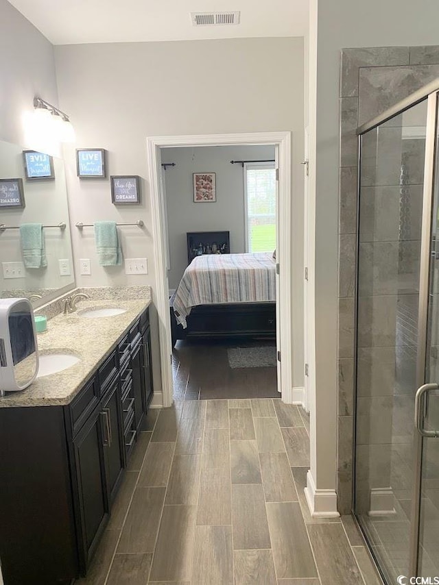 bathroom with a shower with door and vanity