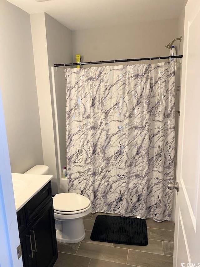 full bathroom with vanity, shower / bath combo with shower curtain, and toilet