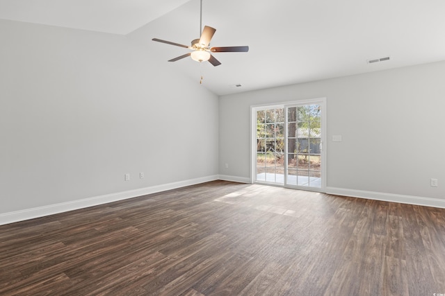 spare room with dark wood-type flooring, lofted ceiling, visible vents, and baseboards