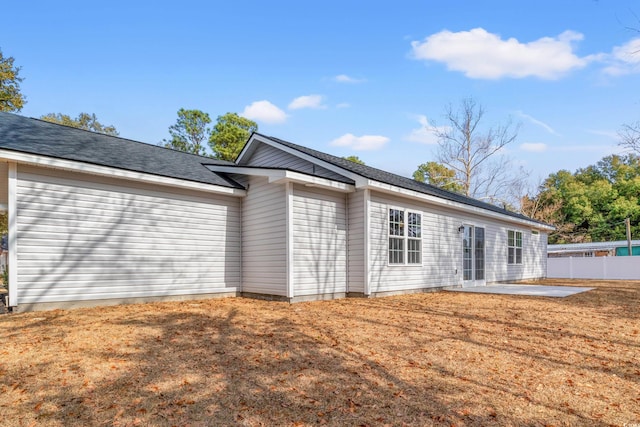 back of property with a patio area, fence, and a lawn