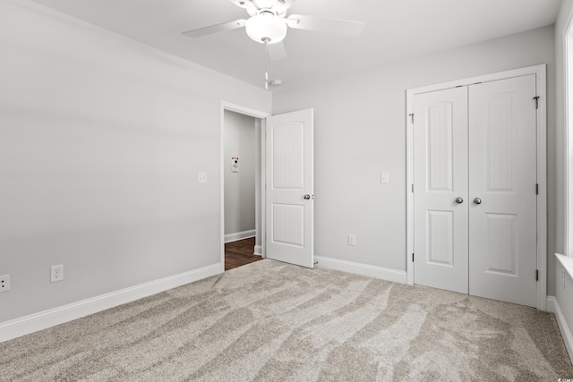 unfurnished bedroom featuring a closet, carpet flooring, a ceiling fan, and baseboards