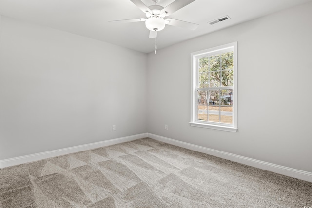 empty room with light carpet, a ceiling fan, visible vents, and baseboards