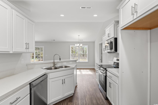 kitchen featuring visible vents, appliances with stainless steel finishes, a peninsula, a sink, and a wealth of natural light