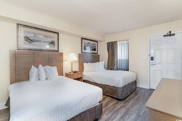 bedroom with dark wood-type flooring and a textured ceiling