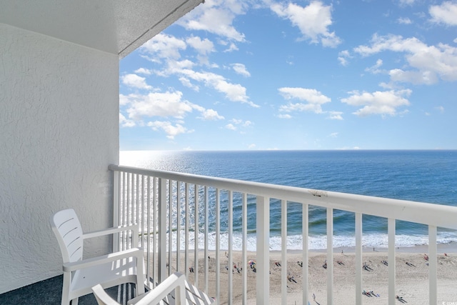 balcony featuring a water view and a beach view