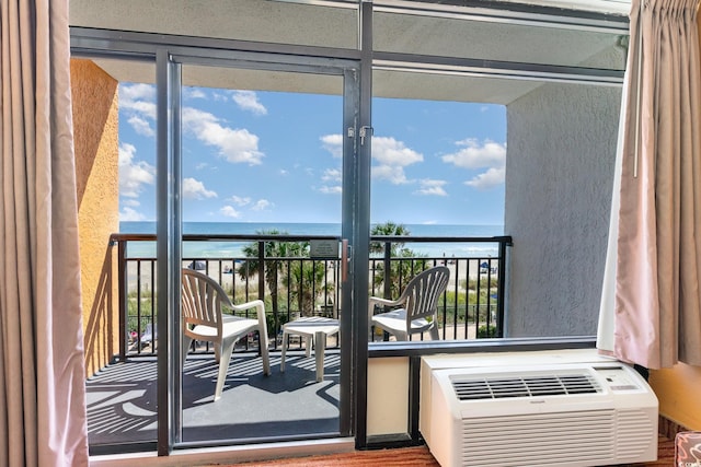 balcony featuring a water view and a wall unit AC