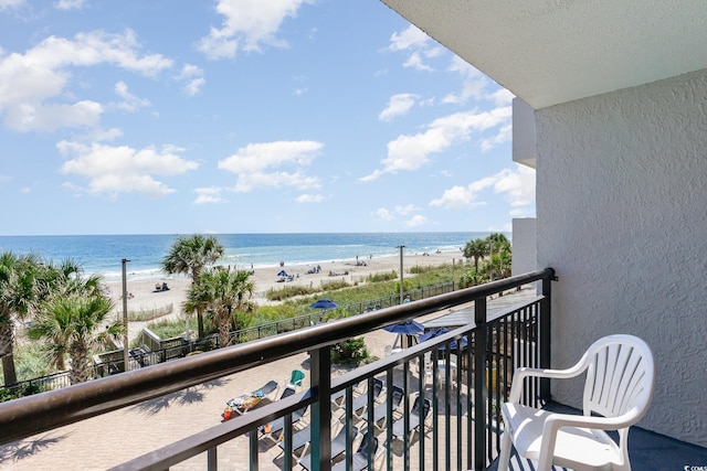 balcony featuring a water view and a beach view