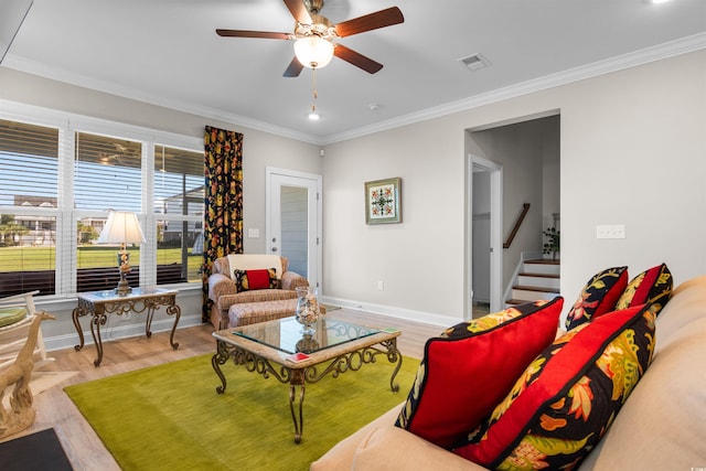 living room featuring light wood-type flooring, ornamental molding, and ceiling fan