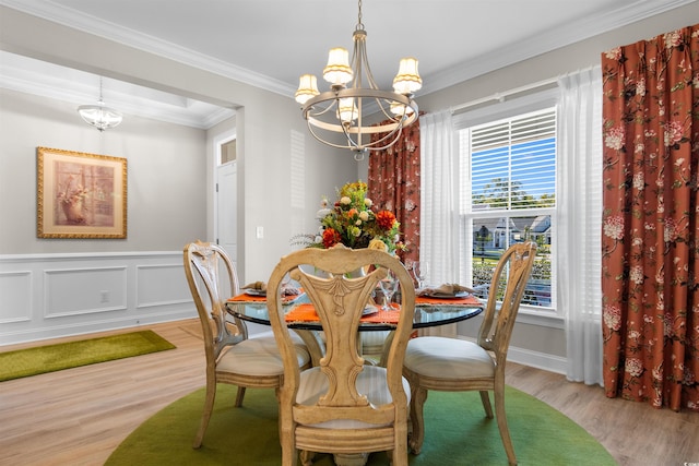 dining area with crown molding, light hardwood / wood-style floors, and an inviting chandelier