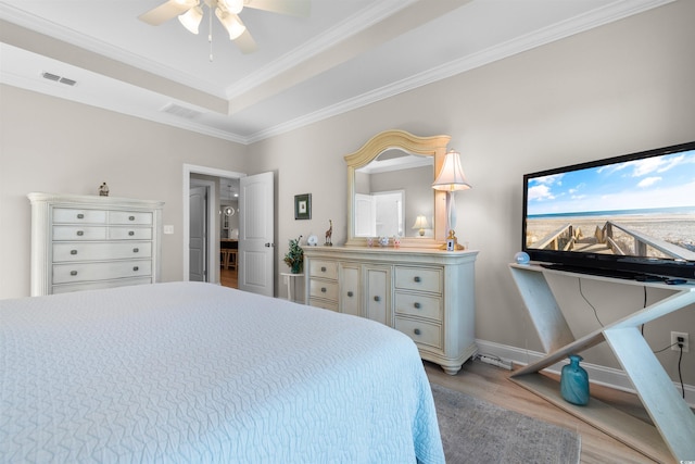 bedroom featuring ceiling fan, light wood-type flooring, and crown molding