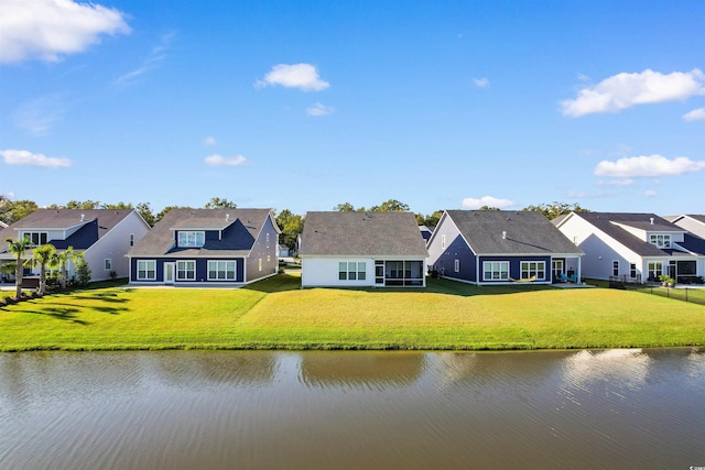 rear view of house featuring a lawn and a water view