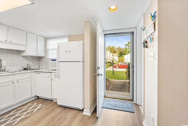 kitchen featuring white cabinets, white appliances, light hardwood / wood-style flooring, and tasteful backsplash