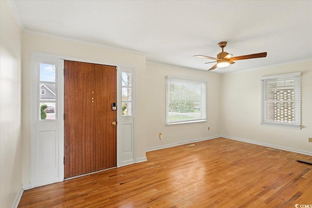 foyer featuring light wood-type flooring, crown molding, and ceiling fan