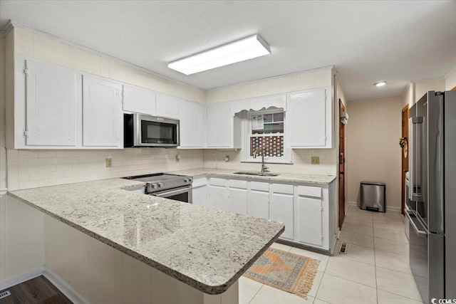 kitchen featuring kitchen peninsula, sink, stainless steel appliances, and white cabinets