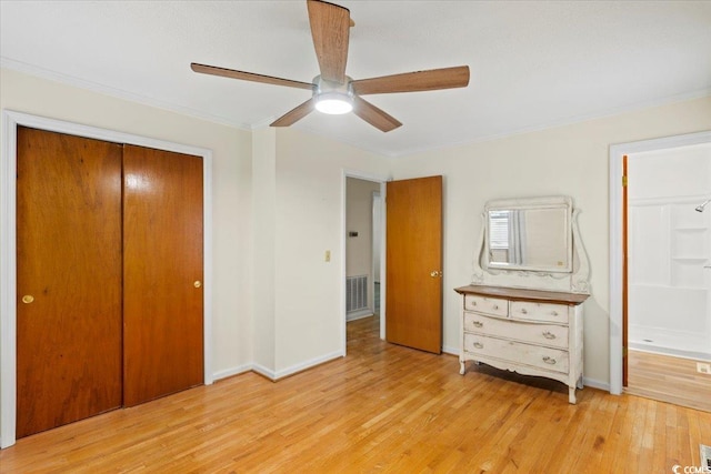 unfurnished bedroom with light hardwood / wood-style flooring, a closet, ceiling fan, and crown molding