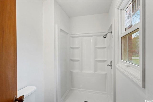 bathroom with walk in shower and toilet