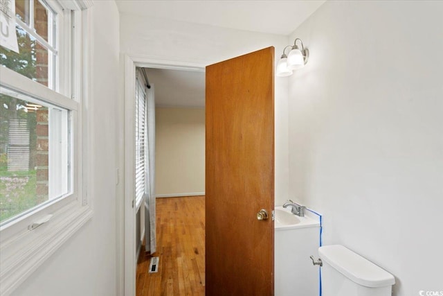 bathroom with wood-type flooring and toilet