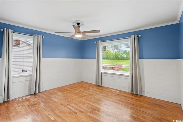 spare room featuring ceiling fan, hardwood / wood-style flooring, and crown molding