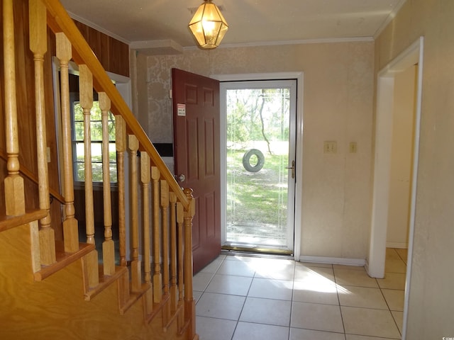 tiled entrance foyer featuring crown molding