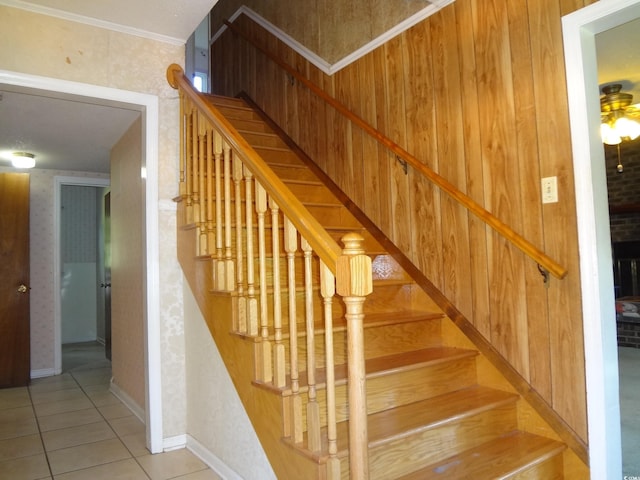 staircase with tile patterned floors, ceiling fan, and crown molding